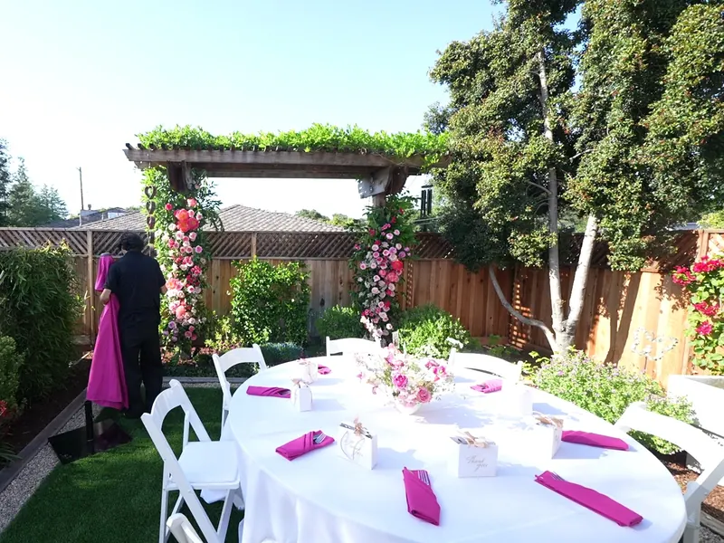 Tables set outdoors with linens and umbrellas for an afternoon event in Los Altos Hills