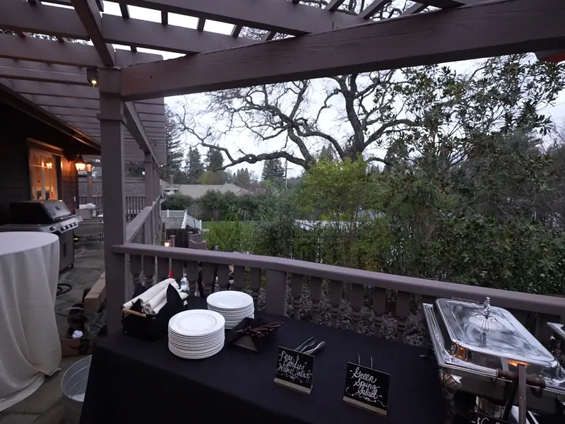 Tables set outdoors with linens and umbrellas for an afternoon event in Campbell