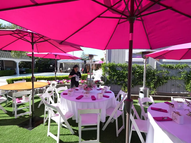 Tables set outdoors with linens and umbrellas for an afternoon event in Mountain View