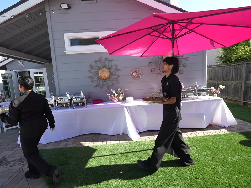 Tables set outdoors with linens and umbrellas for an afternoon event in Palo Alto