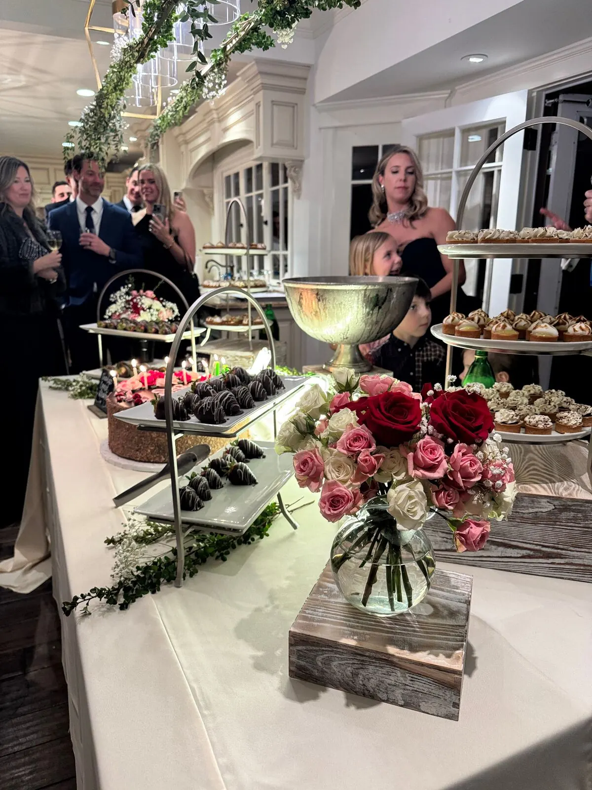 Wedding sweets table with chocolate-covered strawberries and garden roses worked straight into the display — floral dessert styling for Stanford catering receptions