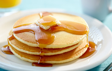 Breakfast catering with a stack of pancakes with honey or buttermilk