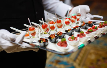Appetizers are being served by the waiter at a wedding