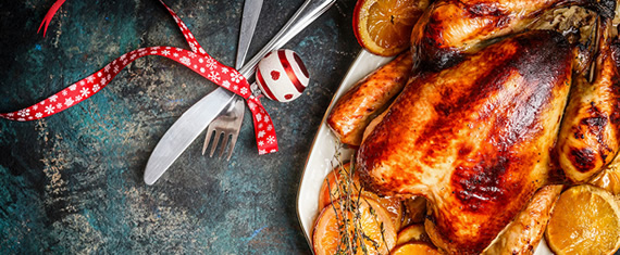Whole roasted turkey with knife and fork decorated with lemons