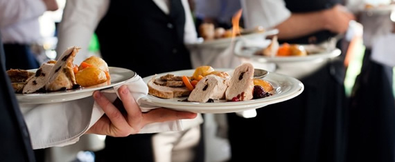 Waiters are bringing dinner to the tables for holiday catering